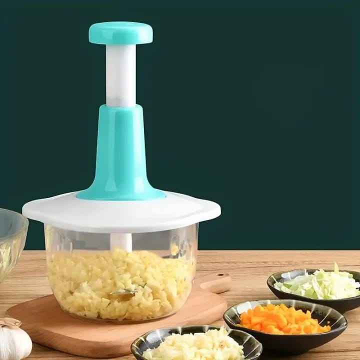 AVIOX manual press food chopper with chopped garlic in a clear container on a wooden table.