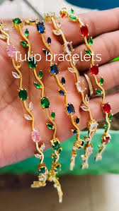 AVIOX multi-color tulip bracelets with floral designs and colorful gemstones on a hand